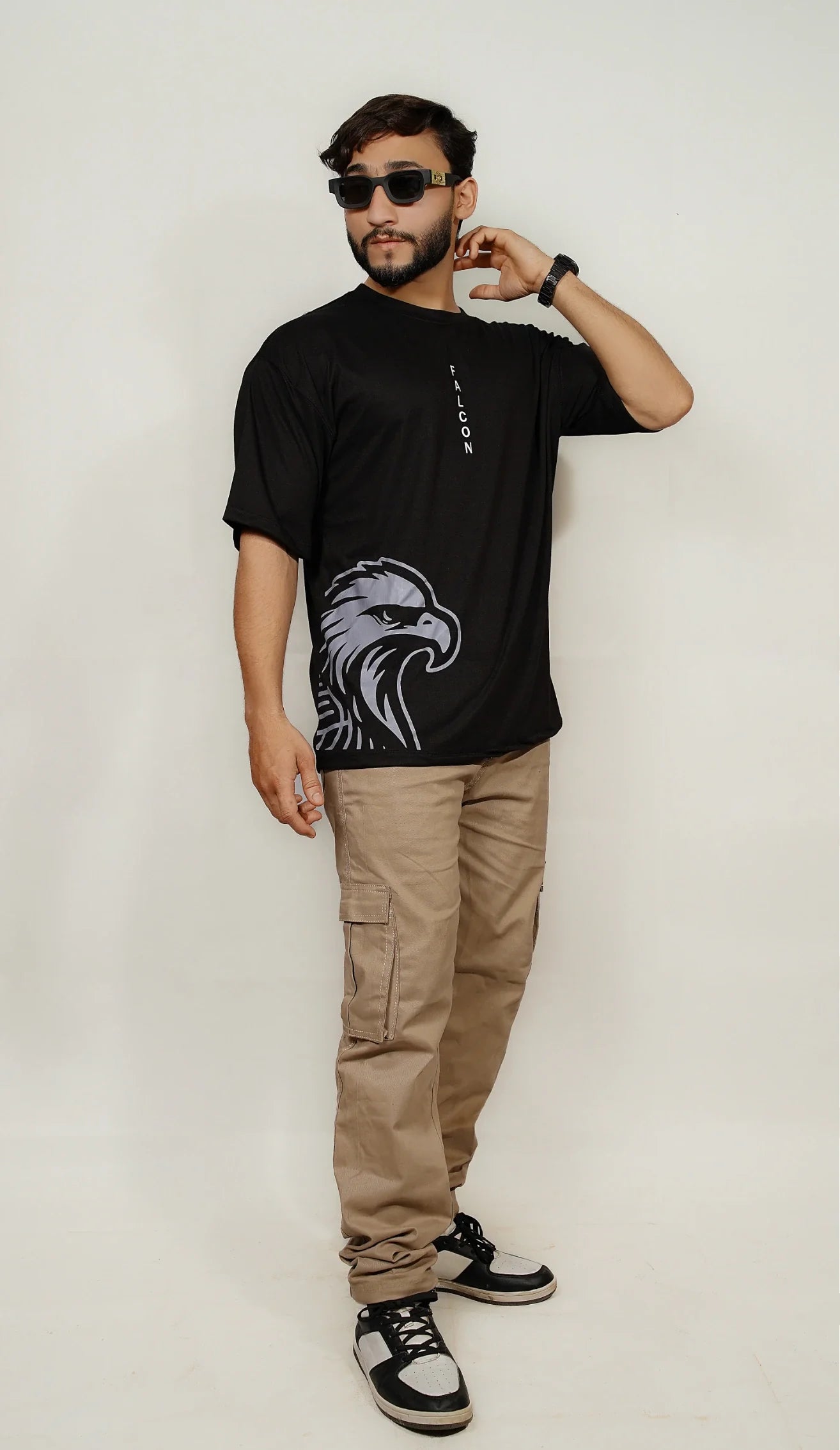 Model wearing black Falcon oversized drop-shoulder t-shirt with minimalist front insignia