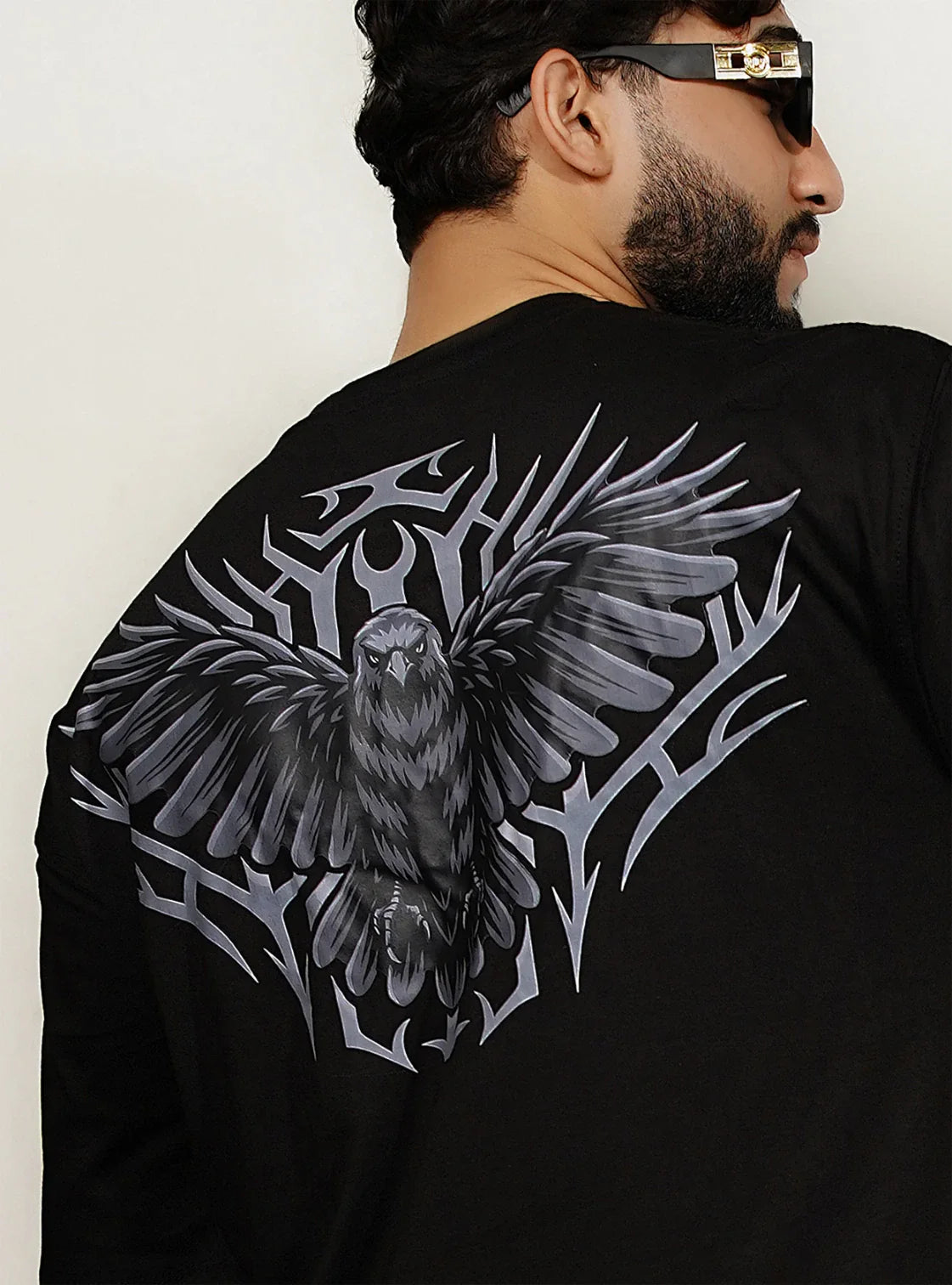 Model wearing black Falcon oversized streetwear t-shirt showing large falcon emblem back design